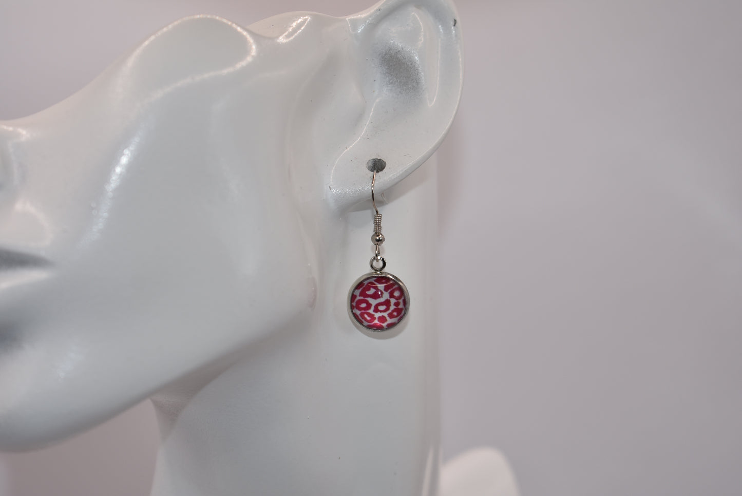 "Add some 🐆🌸 to your outfit with our Safari Collection! These fuschia pink leopard print earrings are not only super cute, but also perfect for sensitive ears with their silver hypoallergenic posts. Get yourself some fun and stylish cabochon hanging earrings today!"