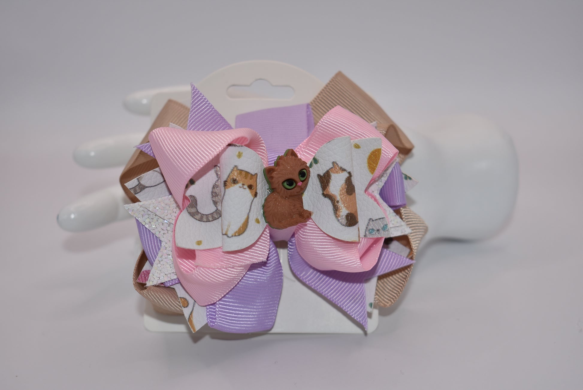 Meow! Add some feline fun to your hair with Nana's Collection adorable cat bow. Made of faux leather and ribbon with an alligator clip for easy use, it's the purr-fect accessory for any cat lover. No hair-meowning necessary!