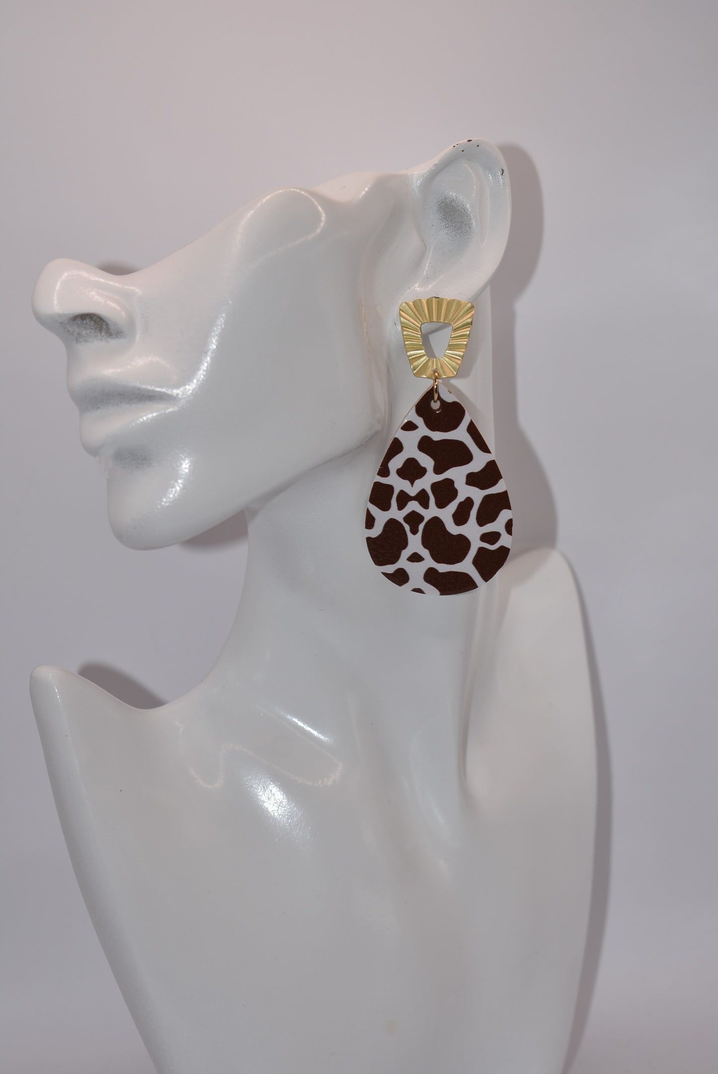 This Safari Collection earring is the perfect for adding a bit of wildness to your Fall look! The unique gold posts hold a playful brown cow print teardrop faux leather, so you can bring a bit of the barnyard into your wardrobe. Yee-haw!