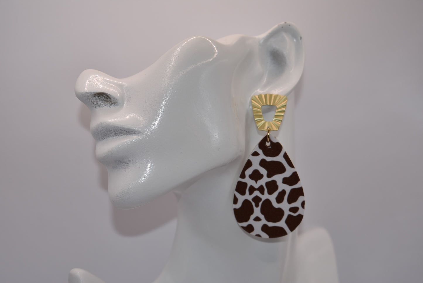 This Safari Collection earring is the perfect for adding a bit of wildness to your Fall look! The unique gold posts hold a playful brown cow print teardrop faux leather, so you can bring a bit of the barnyard into your wardrobe. Yee-haw!