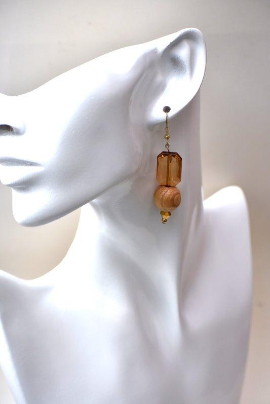 Add some playful charm to your outfit with these gold hypoallergenic hook earrings. Featuring an amber gem with a round wood bead and small beading at the bottom, they are perfect for dressing up or down. A must-have addition to any wardrobe!