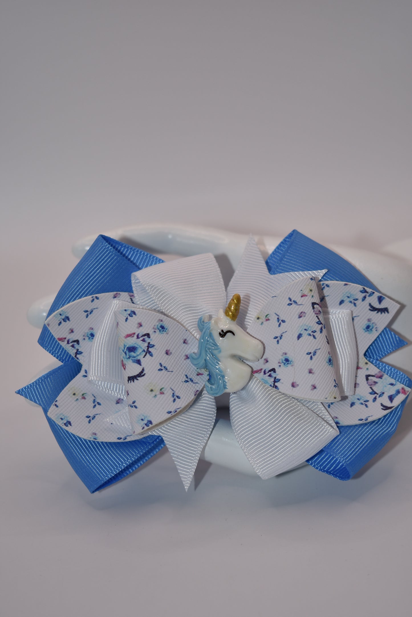 Unleash your little girl's imagination with Nana's Collection! Our Pretty Unicorn motif, made with a mix of blue and white ribbon and luxe faux leather, will have her feeling magical. With this bow, she'll be sure to fall in love with accessorizing (and maybe even unicorns)!