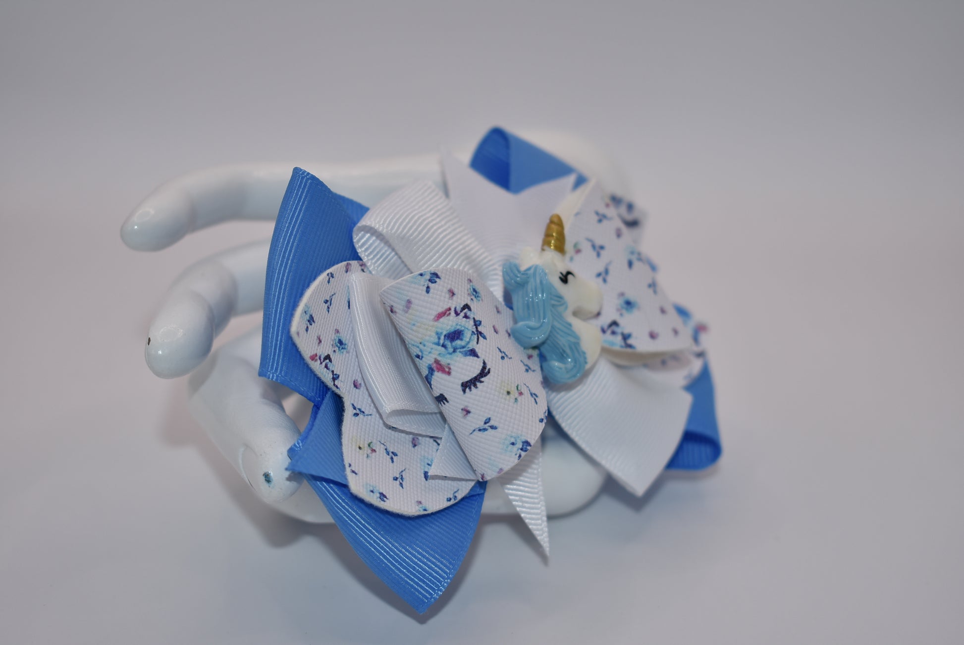 Unleash your little girl's imagination with Nana's Collection! Our Pretty Unicorn motif, made with a mix of blue and white ribbon and luxe faux leather, will have her feeling magical. With this bow, she'll be sure to fall in love with accessorizing (and maybe even unicorns)!