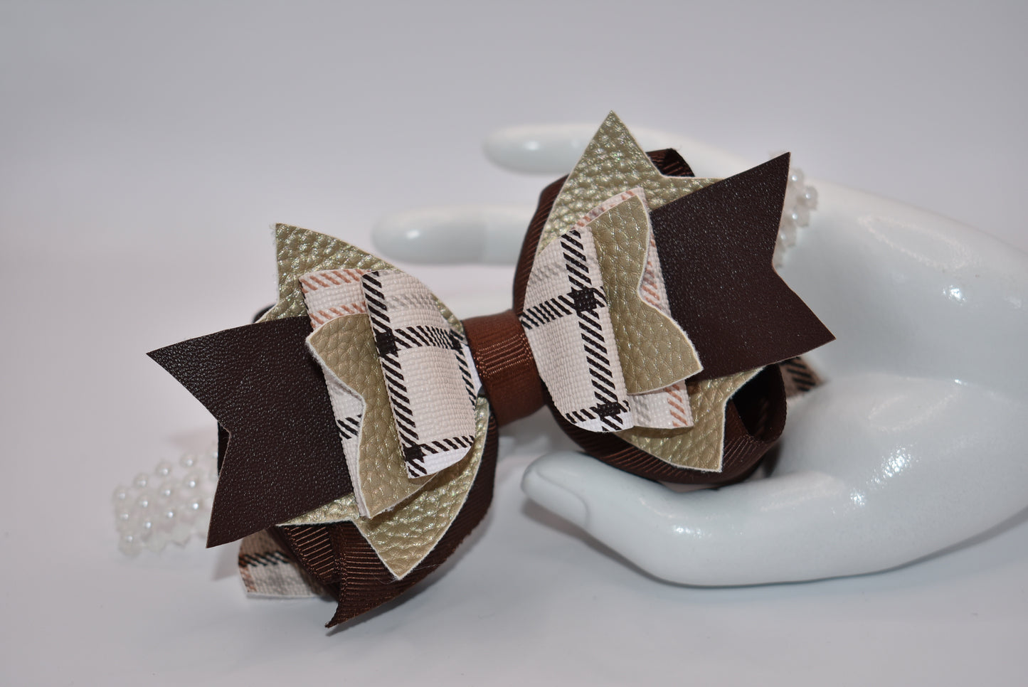 Get the perfect brown bow with Nana's Collection! Made with pretty brown ribbon and faux leather, it's the perfect addition to any outfit. And with a pearl ribbon accent and an easy alligator clip, this bow is sure to add a special touch!