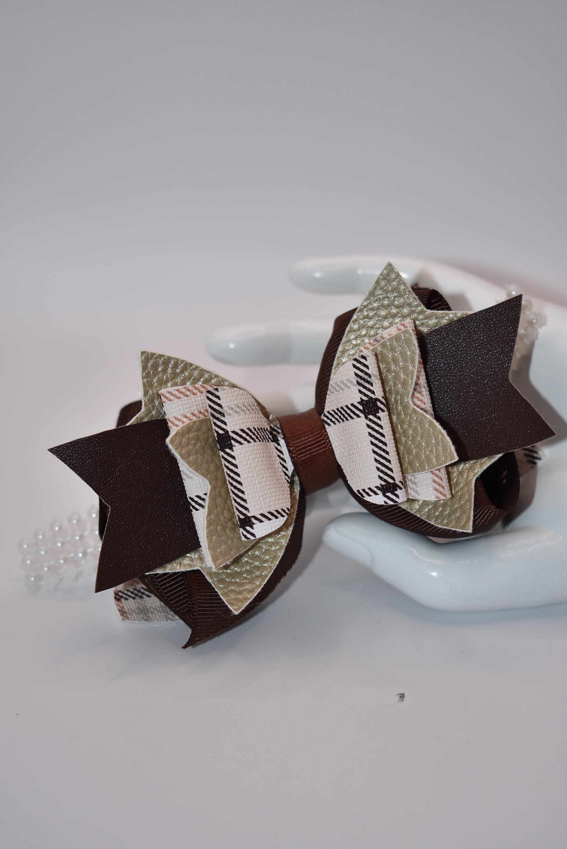 Get the perfect brown bow with Nana's Collection! Made with pretty brown ribbon and faux leather, it's the perfect addition to any outfit. And with a pearl ribbon accent and an easy alligator clip, this bow is sure to add a special touch!