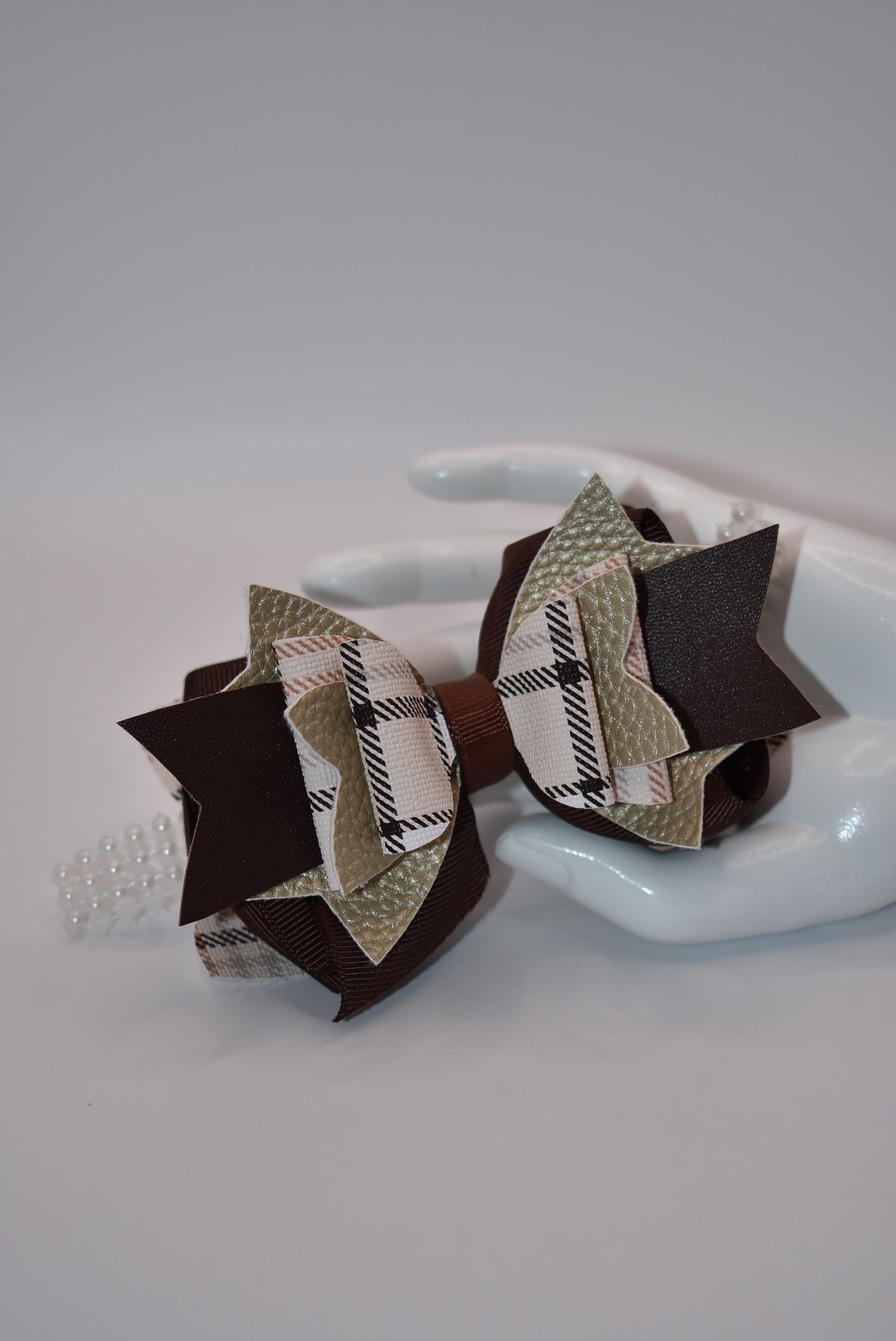 Get the perfect brown bow with Nana's Collection! Made with pretty brown ribbon and faux leather, it's the perfect addition to any outfit. And with a pearl ribbon accent and an easy alligator clip, this bow is sure to add a special touch!