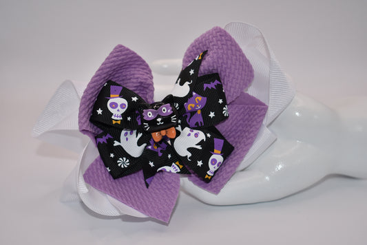 Spook up your Halloween outfit with Nana's Collection's black and purple bow! With an alligator clip for easy styling, you'll be the center of attention as "ghosts and goblins come on out" (wink wink).