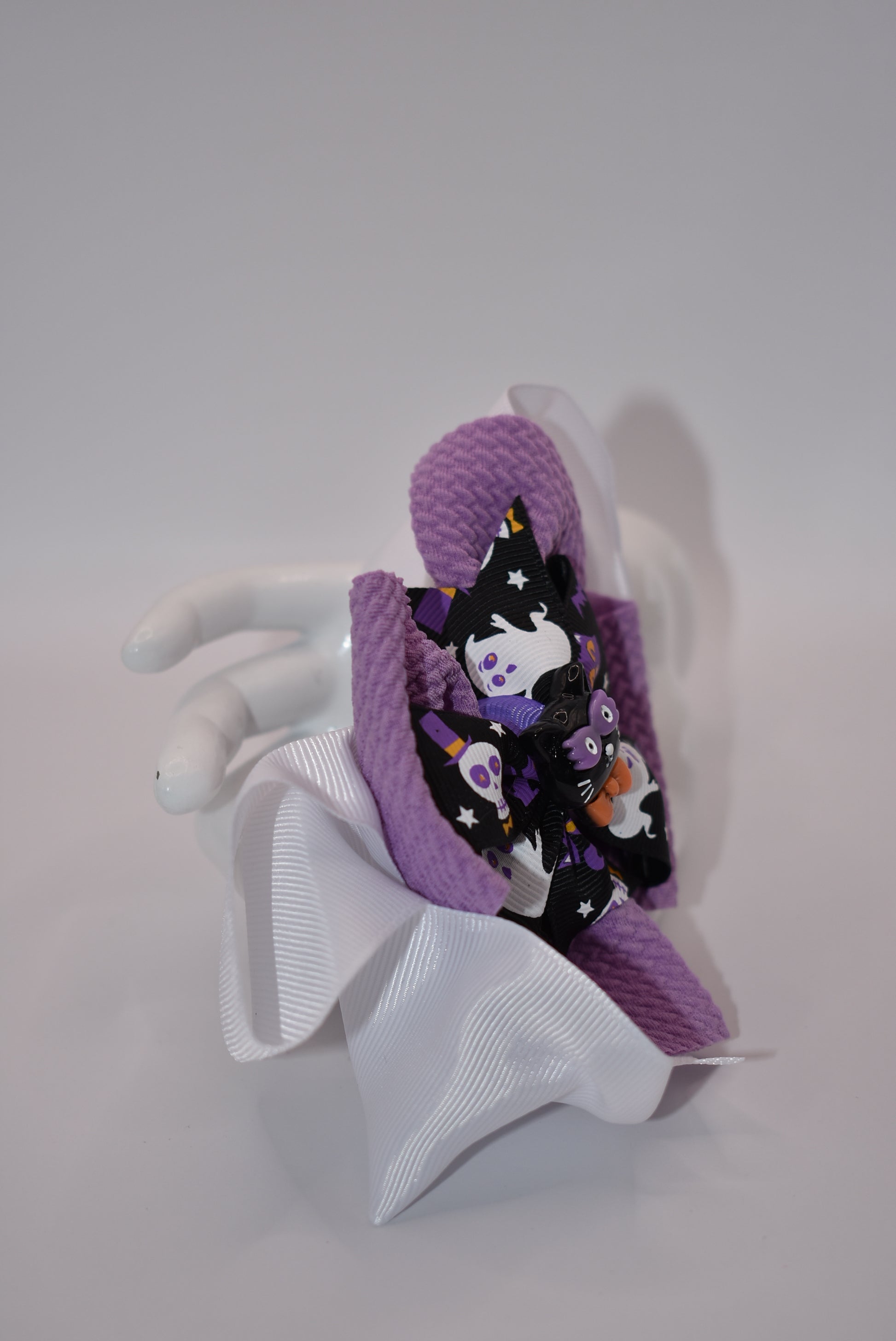 Spook up your Halloween outfit with Nana's Collection's black and purple bow! With an alligator clip for easy styling, you'll be the center of attention as "ghosts and goblins come on out" (wink wink).