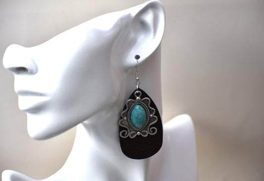 Dark brow faux leather teardrops hold a beautiful turquoise silver pendant.  These beauties hang from silver hooks. You won't be able to take your eyes off of these beauties.  