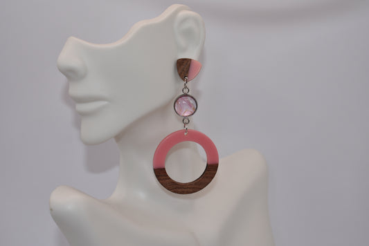 Add a pop of pink to your outfit with our Pink Collection earrings! Crafted with pretty pink resin and wood, these dangly earrings feature a cabochon stone in the middle for a touch of elegance. With hypoallergenic posts for comfort and a lightweight design, they hang about 3 inches from the ear. A must-have for lovers of long, playful earrings.