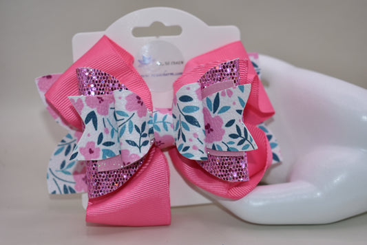 The Bow Corner is a must-have accessory for any little girl! The beautiful 4" pink bow, with its mix of ribbon, glitter, and faux leather, adds a touch of charm to any outfit. The unique flower pattern and covered alligator clip make it both comfortable and easy to wear. (Your little one will look so cute you'll pinkie-swear it!)
