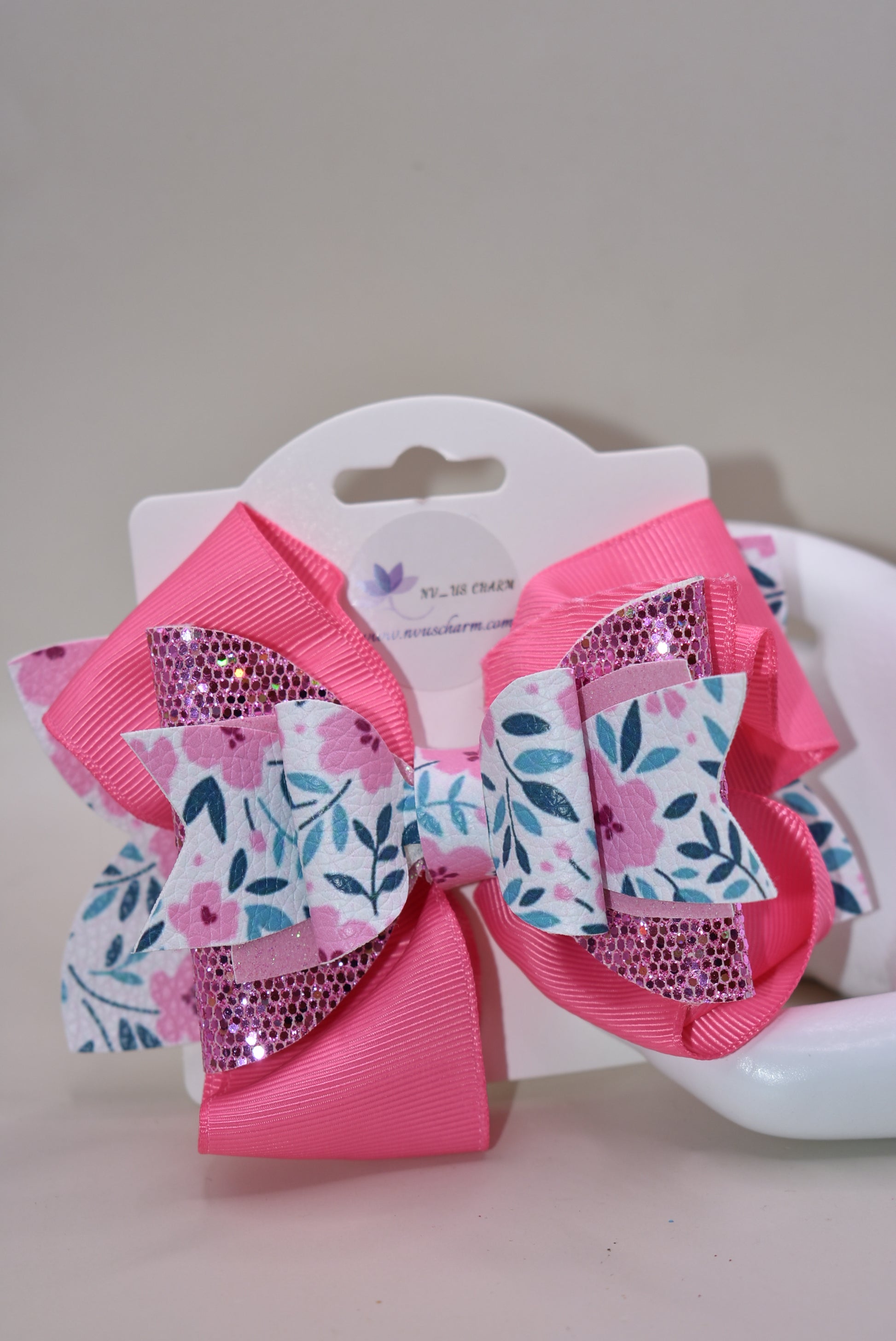 The Bow Corner is a must-have accessory for any little girl! The beautiful 4" pink bow, with its mix of ribbon, glitter, and faux leather, adds a touch of charm to any outfit. The unique flower pattern and covered alligator clip make it both comfortable and easy to wear. (Your little one will look so cute you'll pinkie-swear it!)