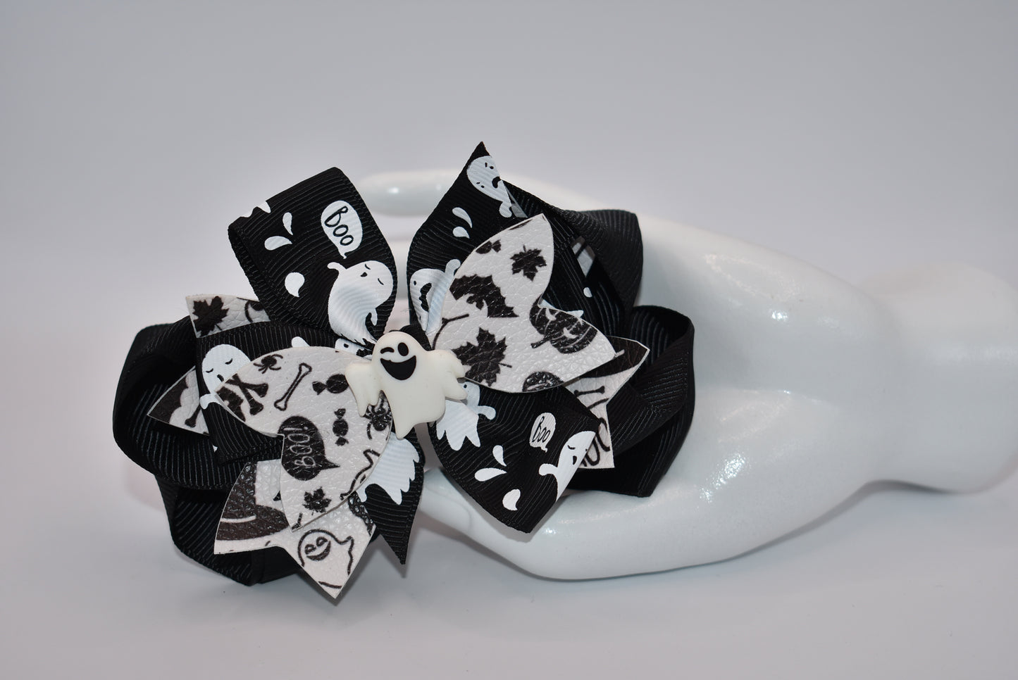 Get ready for Halloween with Nana's Collection! This hair bow features a playful combination of black and white, with a ghost motif and layers of fun ribbon. Complete with an aligator clip, it's the perfect accessory for a spooky look. (Boo-tiful!)