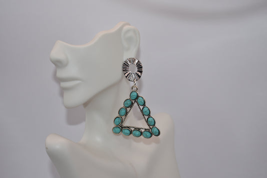 Unleash your inner cowgirl with our Western Collection earrings! These gorgeous dangling pieces add a touch of western style to any outfit. Measuring at 2 and 1/2 inches, they may be on the heavier side, but trust us, they're worth the weight. Hypoallergenic oval silver plated posts hold the triangular aqua beads for a fun and unique look. Saddle up and make a statement with these beauties!