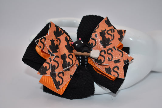 Nana's Collection: Adorable and spooky bow for your little one! Featuring a cute kitty broom charm and a perfect black and orange color combination, this bow is the perfect addition to any Halloween outfit. The alligator clip makes it easy to put on and take off. (Meow!)