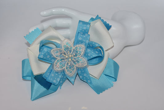 Add a splash of charm with this pretty aqua and cream ribbon adorned with a sparkly flower and tiny pearls ✨🌸. The comfy alligator clip keeps it secure while adding a touch of elegance. Simply beautiful and perfect for brightening any day! 💖🎀