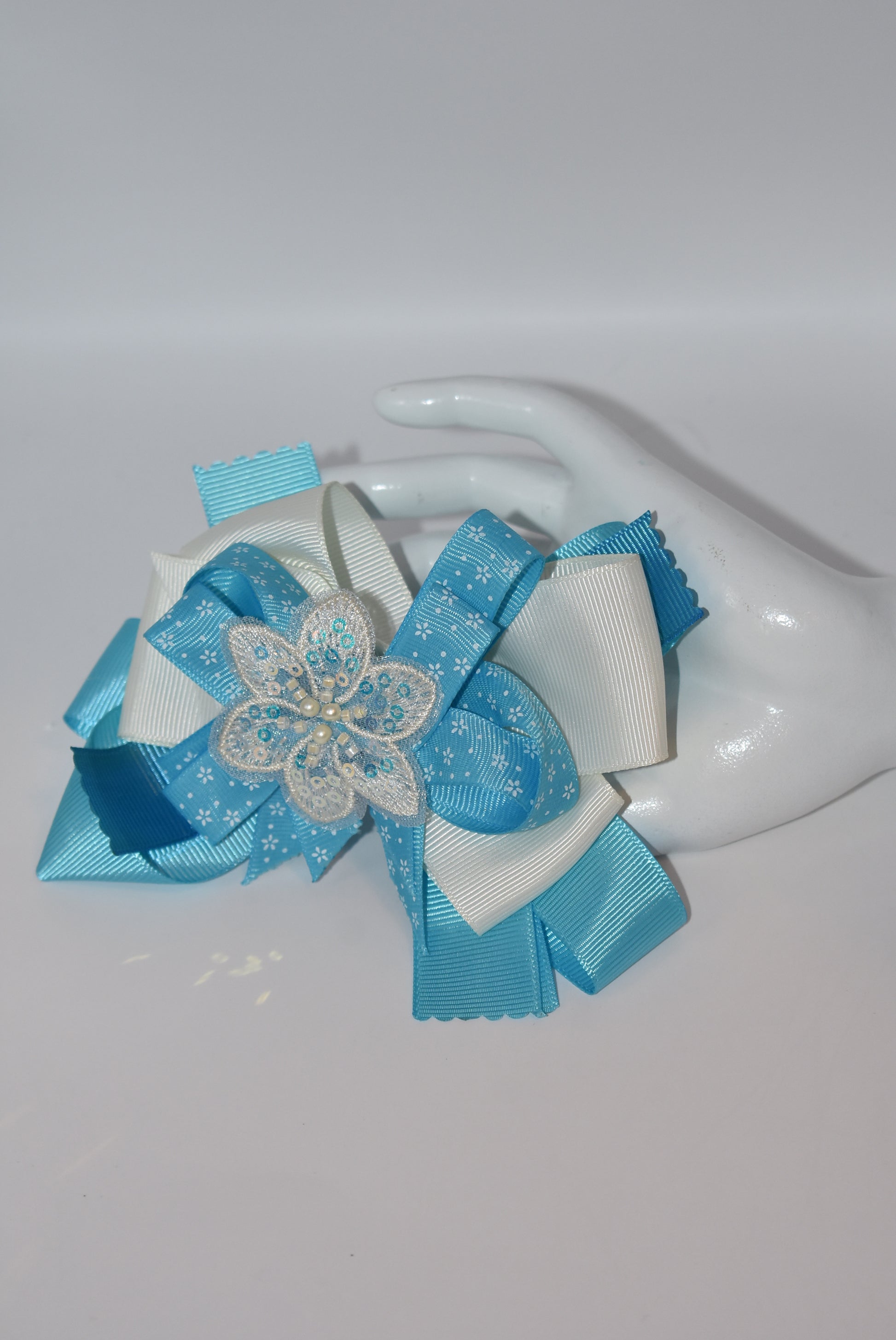 Add a splash of charm with this pretty aqua and cream ribbon adorned with a sparkly flower and tiny pearls ✨🌸. The comfy alligator clip keeps it secure while adding a touch of elegance. Simply beautiful and perfect for brightening any day! 💖🎀