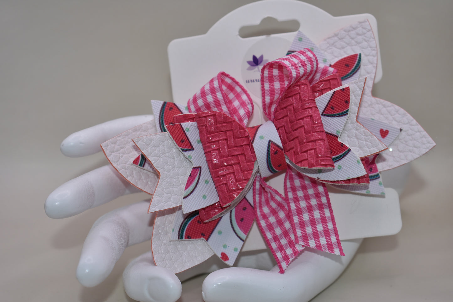 Introducing The Bow Corner! This adorable watermelon designed faux leather bow with a unique pink checkered accent is the perfect summer accessory for your little one. Its covered alligator clip makes for easy styling, while the playful pink and white colors add a fun touch to any outfit. Get ready to wow with this playful and stylish bow!