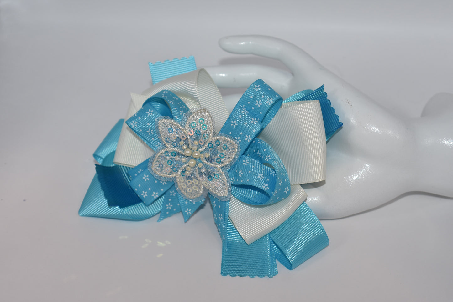 Add a splash of charm with this pretty aqua and cream ribbon adorned with a sparkly flower and tiny pearls ✨🌸. The comfy alligator clip keeps it secure while adding a touch of elegance. Simply beautiful and perfect for brightening any day! 💖🎀