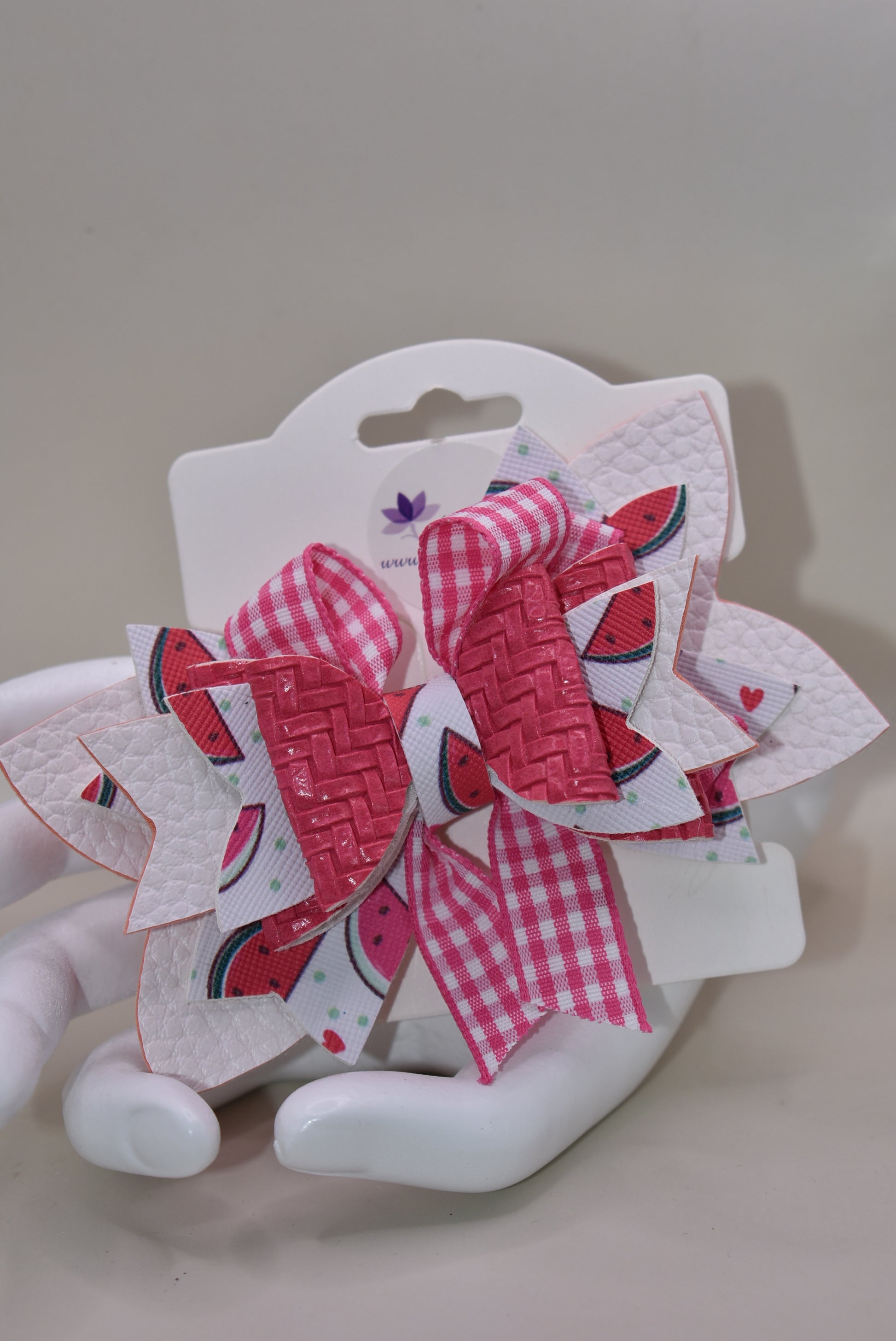 Introducing The Bow Corner! This adorable watermelon designed faux leather bow with a unique pink checkered accent is the perfect summer accessory for your little one. Its covered alligator clip makes for easy styling, while the playful pink and white colors add a fun touch to any outfit. Get ready to wow with this playful and stylish bow!