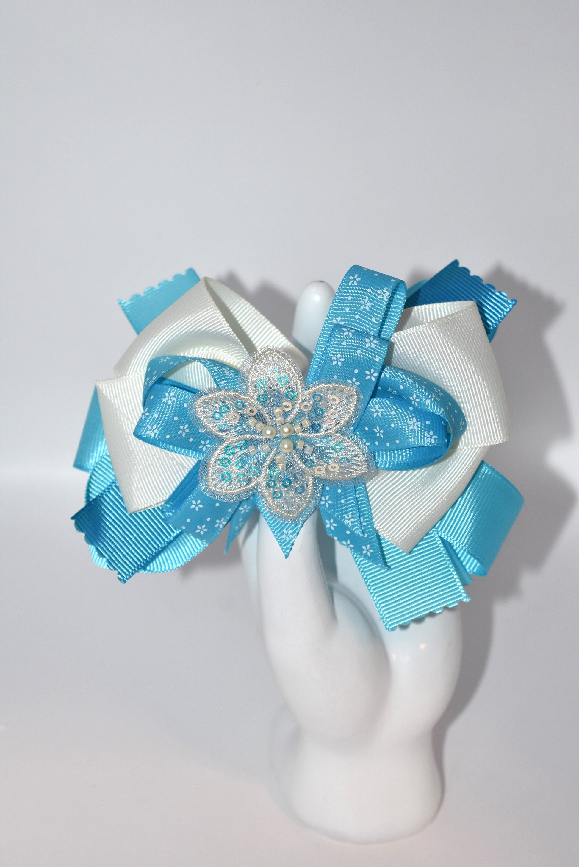 Add a splash of charm with this pretty aqua and cream ribbon adorned with a sparkly flower and tiny pearls ✨🌸. The comfy alligator clip keeps it secure while adding a touch of elegance. Simply beautiful and perfect for brightening any day! 💖🎀