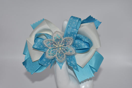 Add a splash of charm with this pretty aqua and cream ribbon adorned with a sparkly flower and tiny pearls ✨🌸. The comfy alligator clip keeps it secure while adding a touch of elegance. Simply beautiful and perfect for brightening any day! 💖🎀