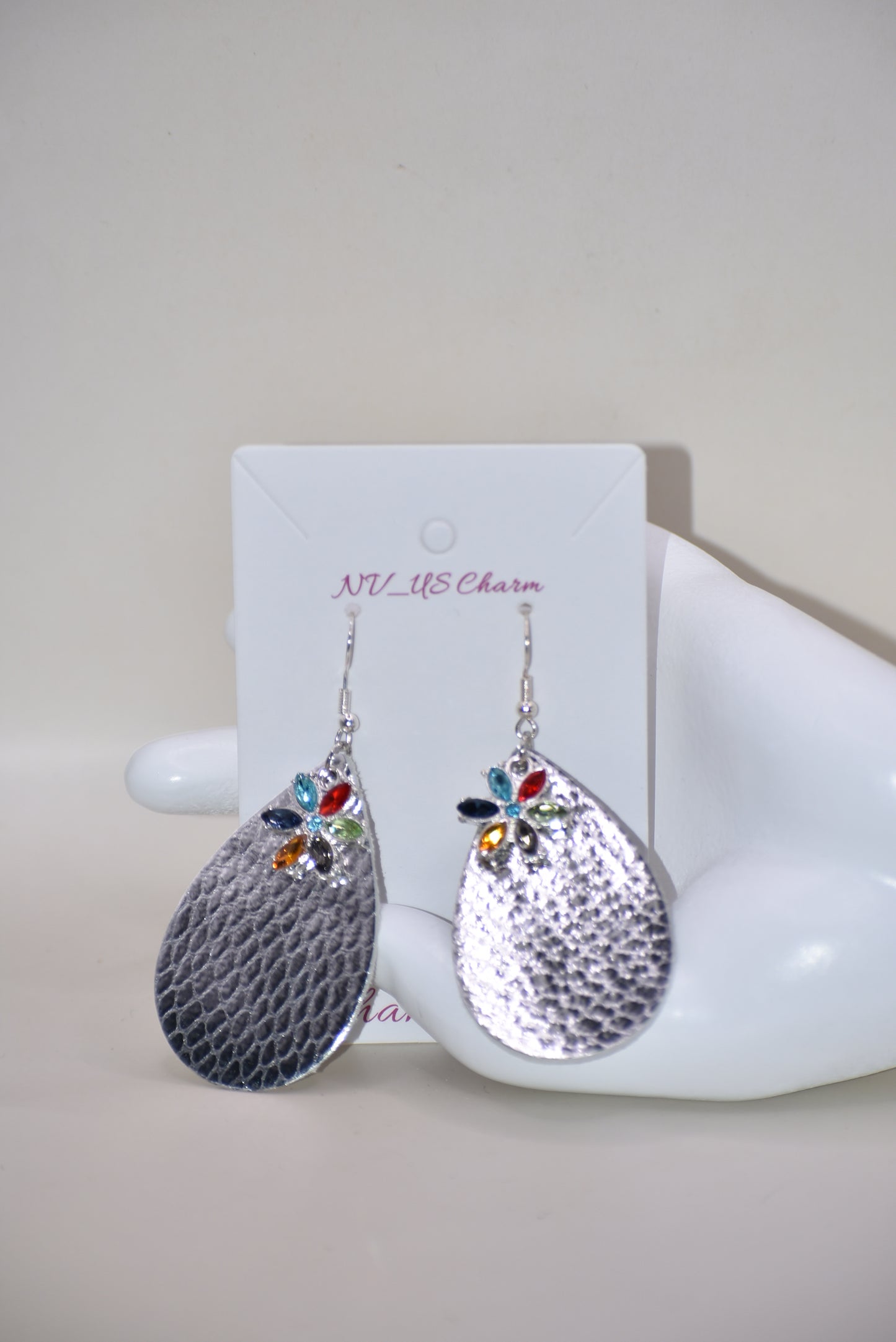 These pretty silver metallic teardrop earrings have a colored crystal flower hanging down and are on silver hooks.&nbsp; Super comfortable.&nbsp; Goes with everything.&nbsp;&nbsp;