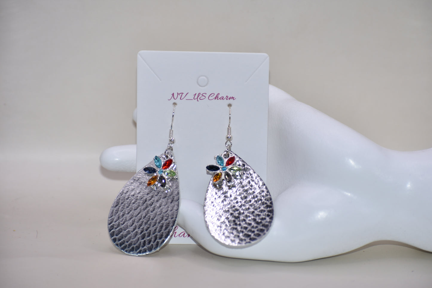 These pretty silver metallic teardrop earrings have a colored crystal flower hanging down and are on silver hooks.&nbsp; Super comfortable.&nbsp; Goes with everything.&nbsp;&nbsp;