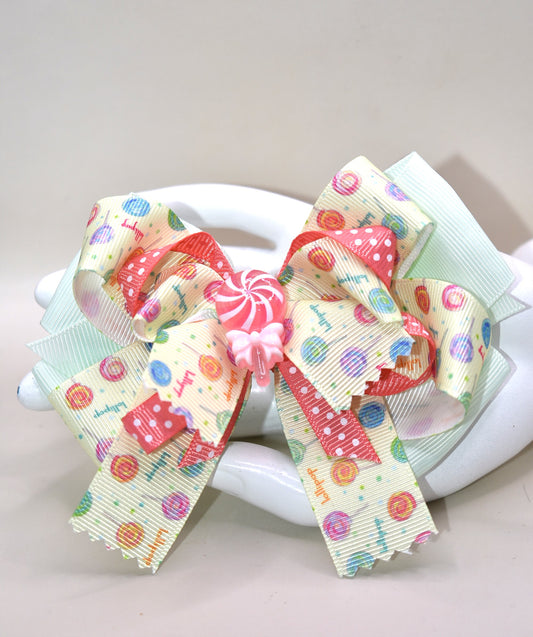 Add a pop of fun to your hair with Nana's Collection 66! Featuring a super fun lollipop bow with a cute charm on top, this ribbon combination of green and peach will make you stand out. The wrapped alligator clip adds comfort for all-day wear. 😍