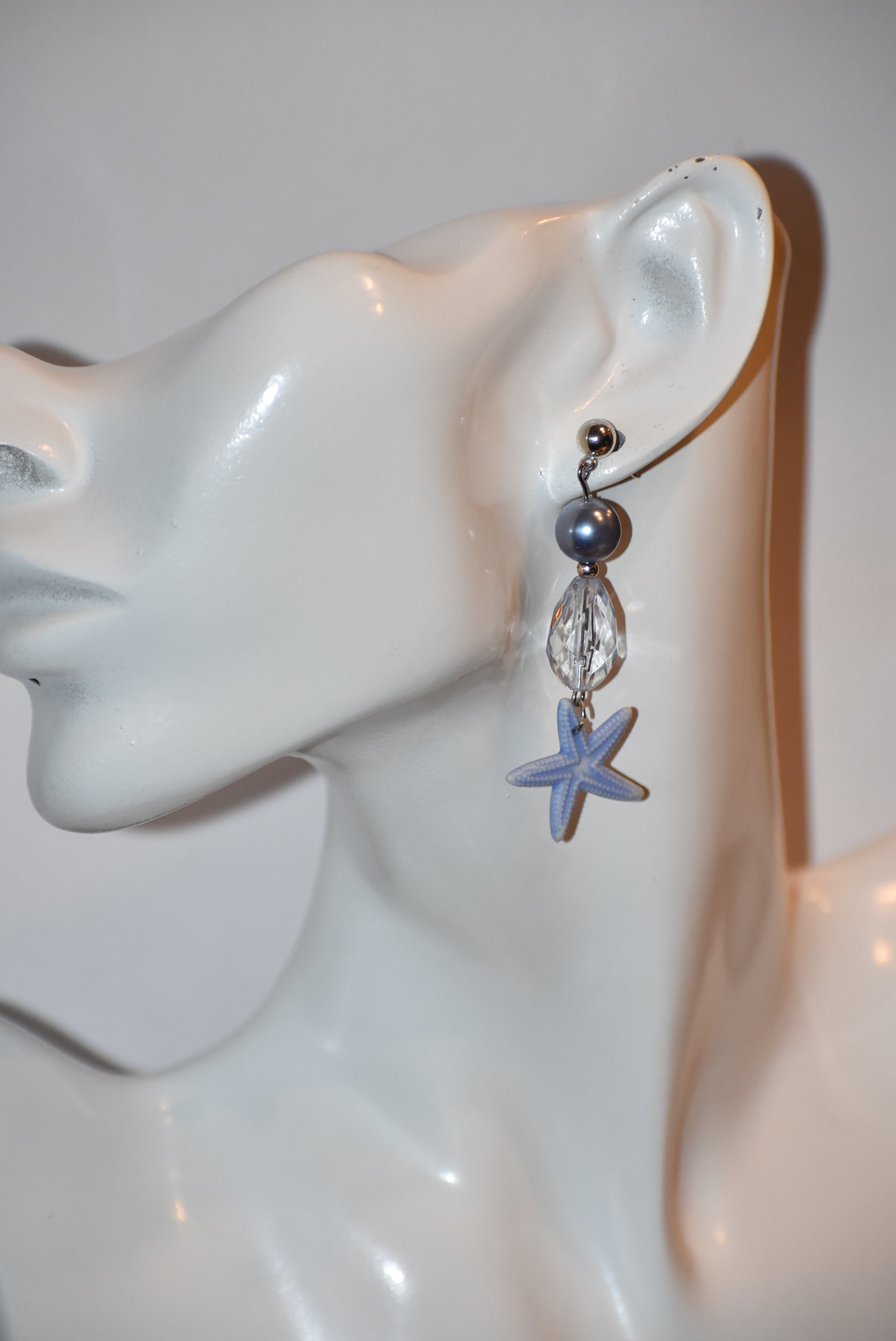 ⚓️ Add a touch of nautical elegance to your wardrobe with our Nautical Collection! These stunning blue pearl, crystal and starfish earrings are held securely by silver hypoallergenic posts. Lightweight and comfortable, they hang 2" off the ear. Perfect for any occasion!