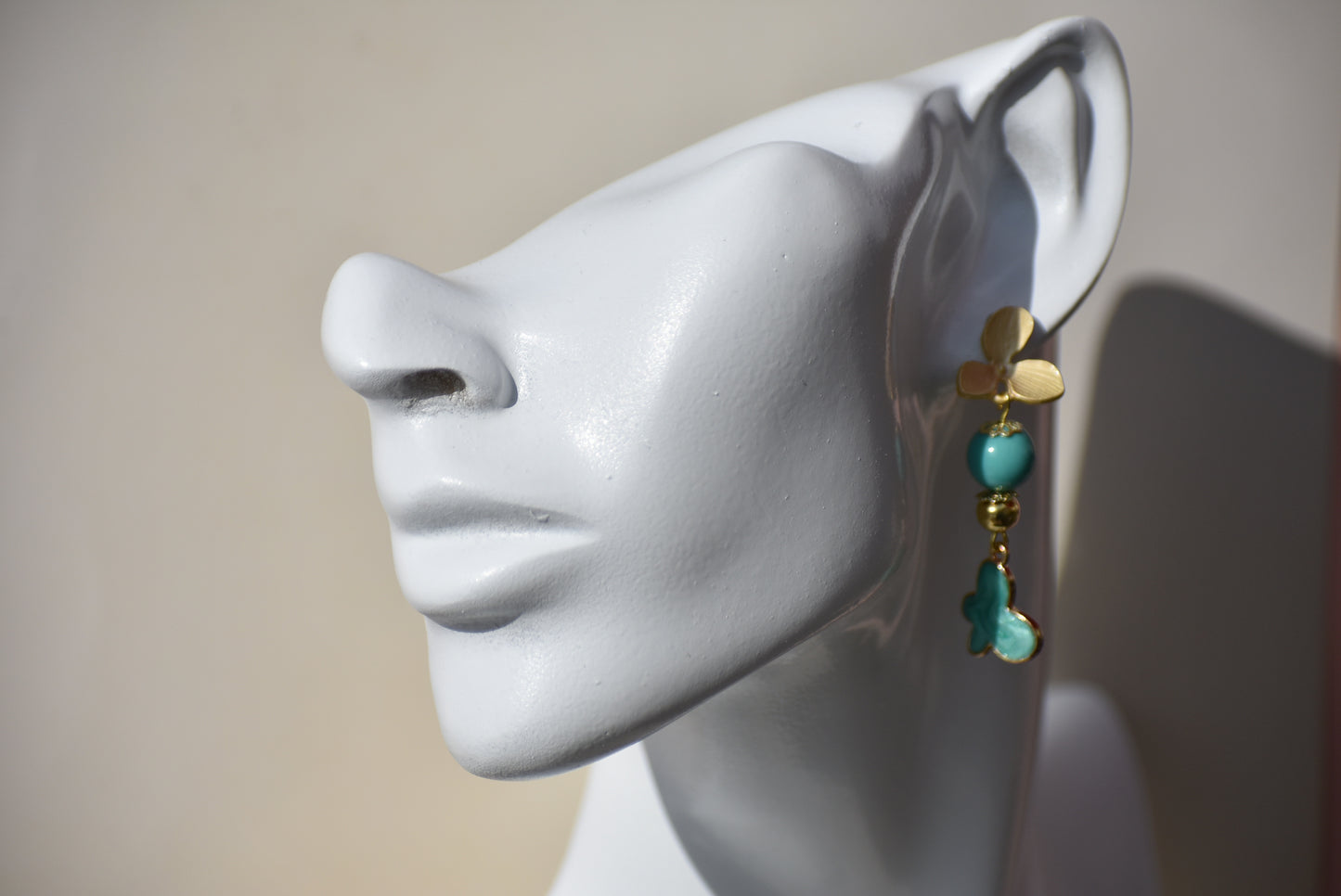 The Green Collection 23 earrings are the perfect addition to any outfit. These elegant earrings feature brushed gold flower posts with pretty jade beading and gold accents. A stunning green charm hangs from the posts, completing the look.