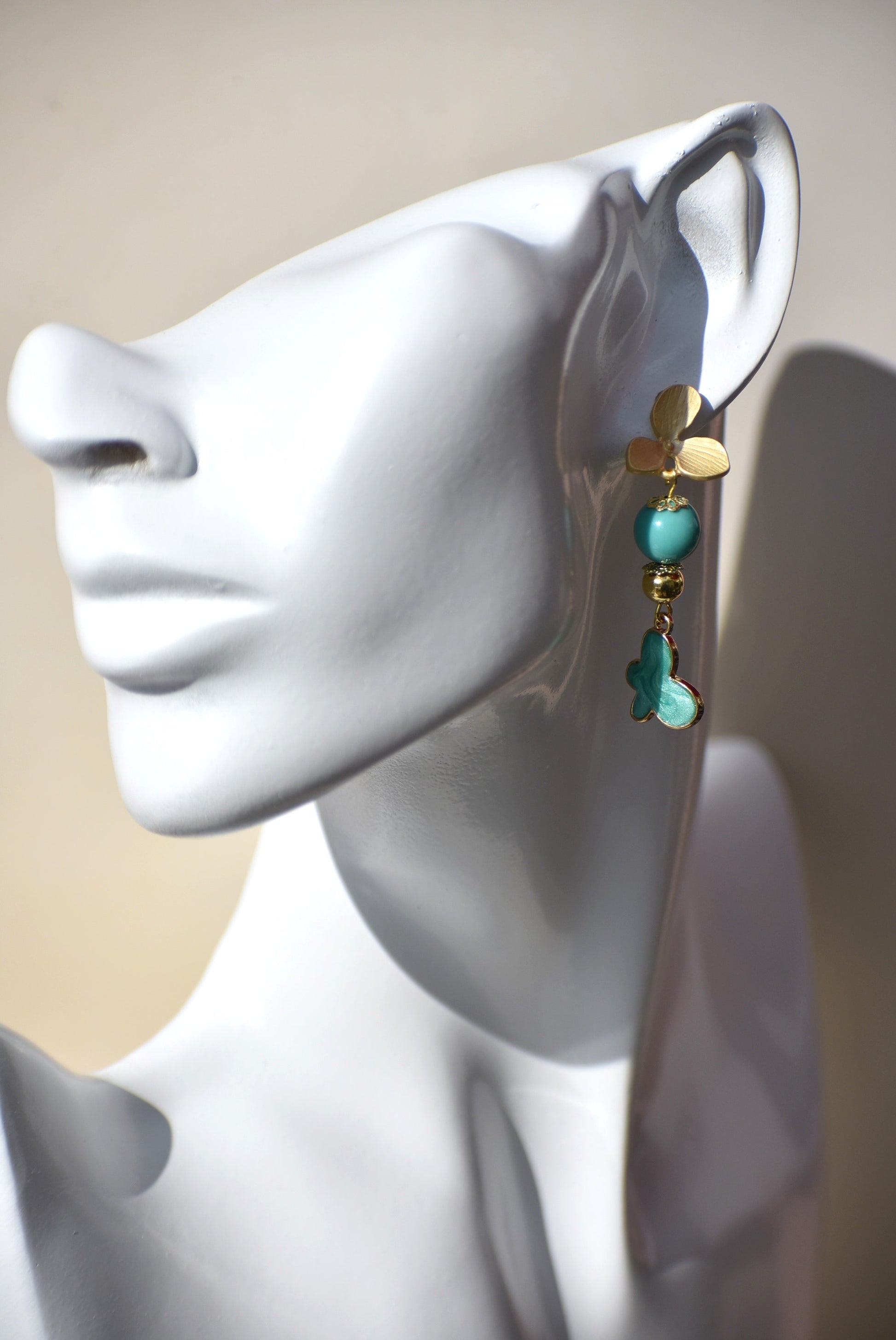 The Green Collection 23 earrings are the perfect addition to any outfit. These elegant earrings feature brushed gold flower posts with pretty jade beading and gold accents. A stunning green charm hangs from the posts, completing the look.