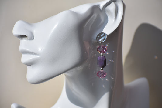 Add a pop of playful color to your outfit with the Purple Collection 13 earrings. Featuring pretty silver hypoallergenic posts, beautiful light purple crystals, and a perfectly sized purple charm, these earrings are a must-have for any lover of the color purple. Classic and versatile, they are the perfect addition to any outfit.