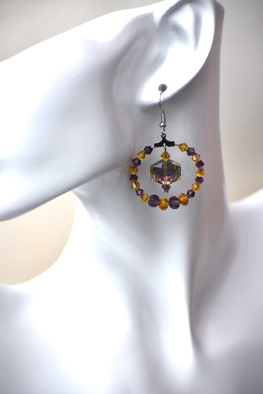 Beautiful shades of purple and gold crystals bring these earrings all kinds of attention.  There is a beautiful crystal in the center that shimmers so many pretty colors in the light.  You will not be disappointed how pretty these earrings look on the ear. This is a one-o-a-kind piece. 