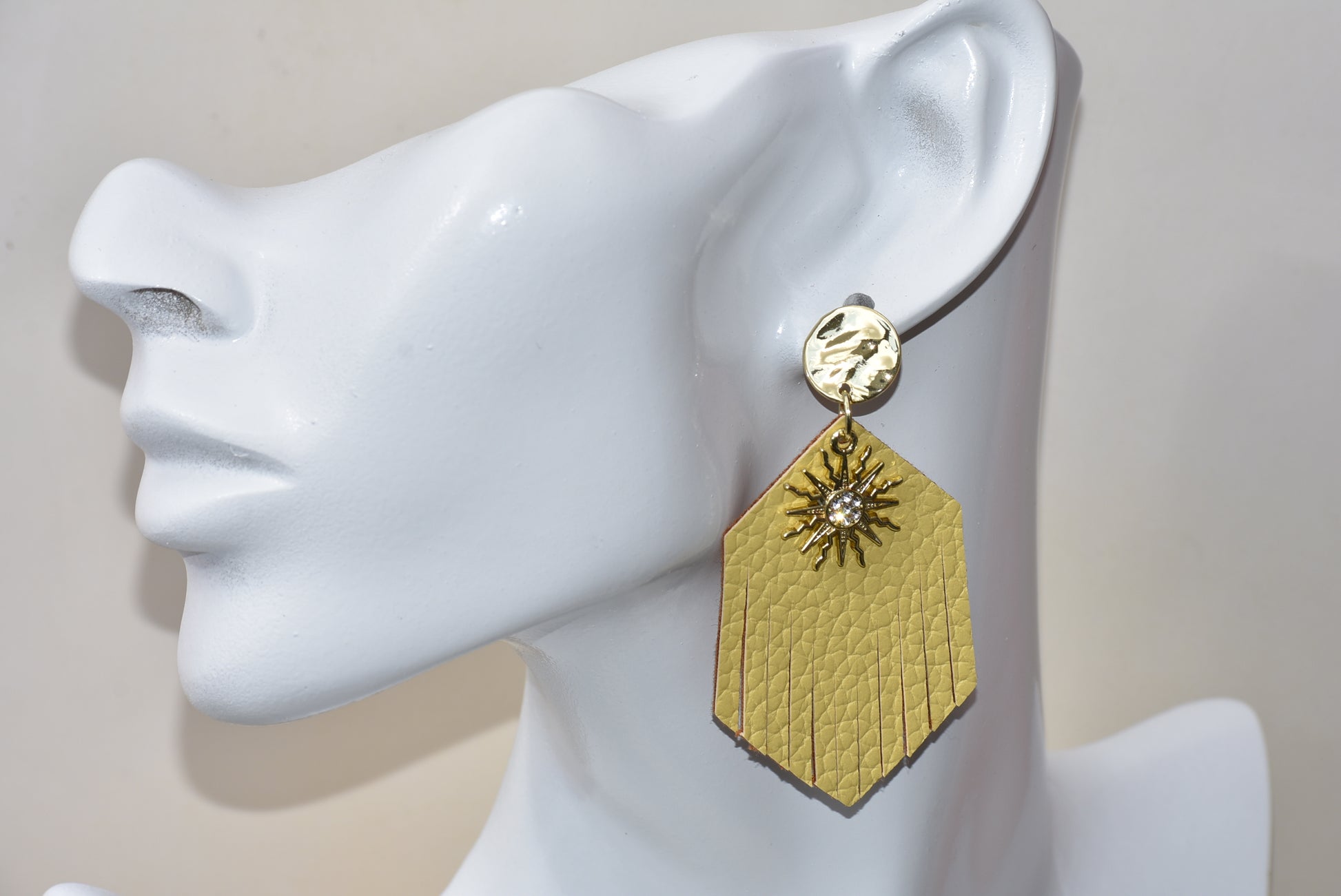 These gold faux leather teardrop fringed earrings have a perfect shiny sun charm with crystal in the center to brighten up your day and definitely your wardrobe.  Super comfortable hanging on gold posts.  