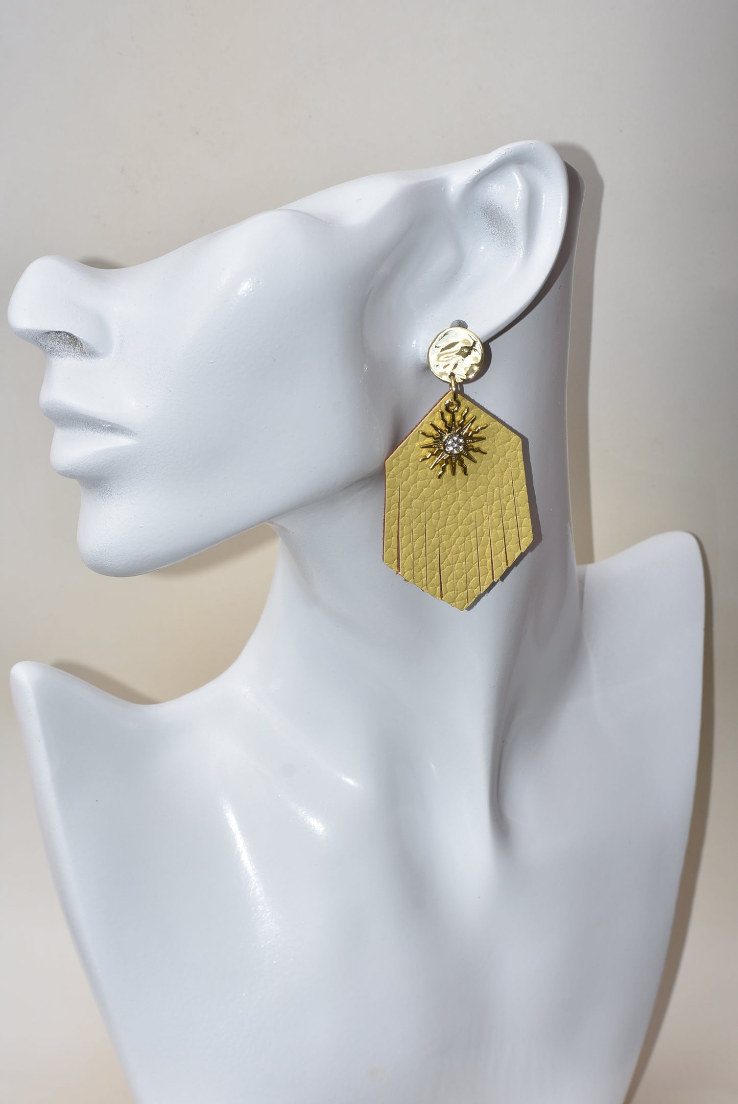 These gold faux leather teardrop fringed earrings have a perfect shiny sun charm with crystal in the center to brighten up your day and definitely your wardrobe.  Super comfortable hanging on gold posts.  