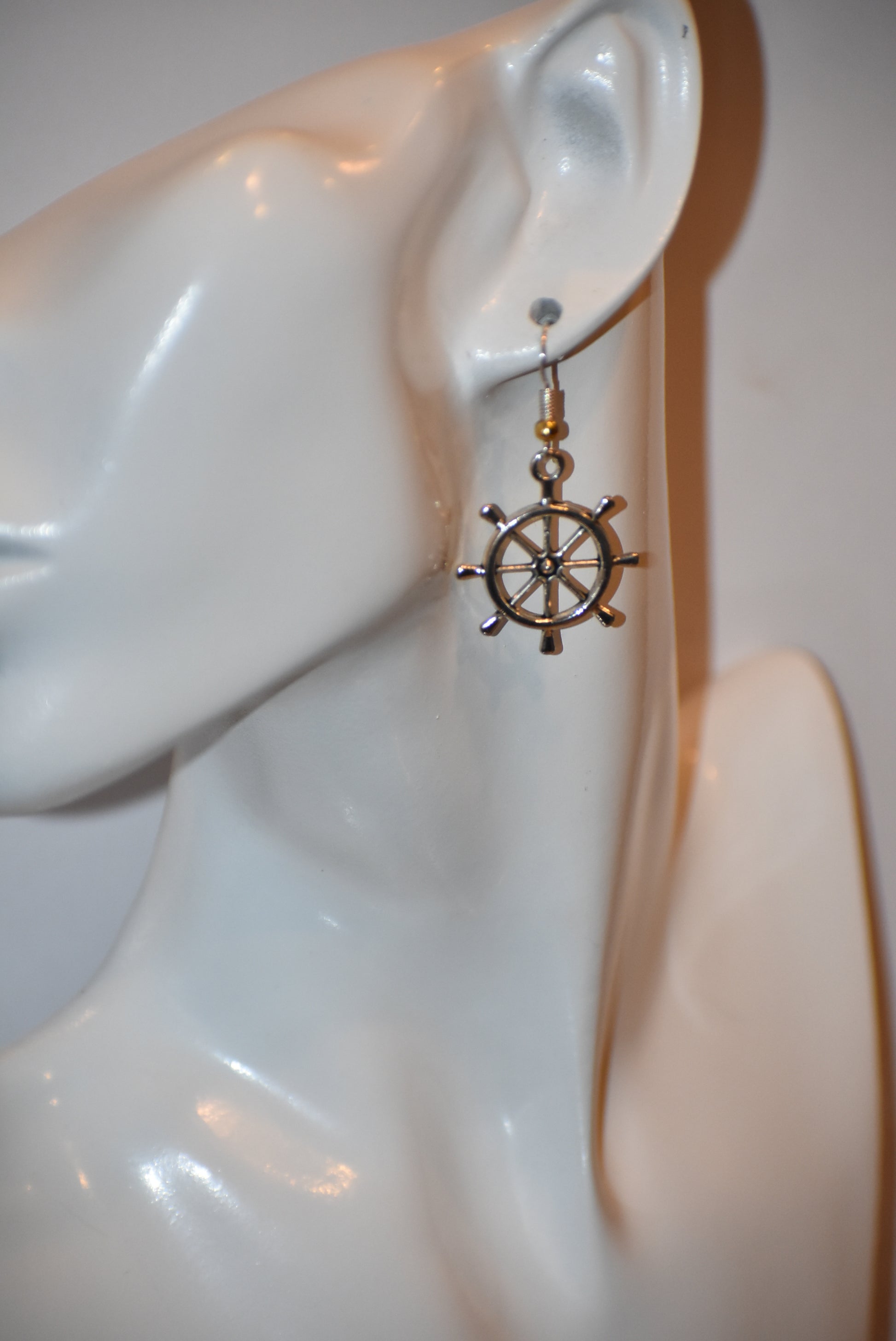 "Add some nautical charm to your look with these adorable wheel earrings ⚓ Made with hypoallergenic silver hooks and a stylish gold ball, these earrings are perfect for any outfit. Look cute and feel comfortable with the Nautical Collection!"