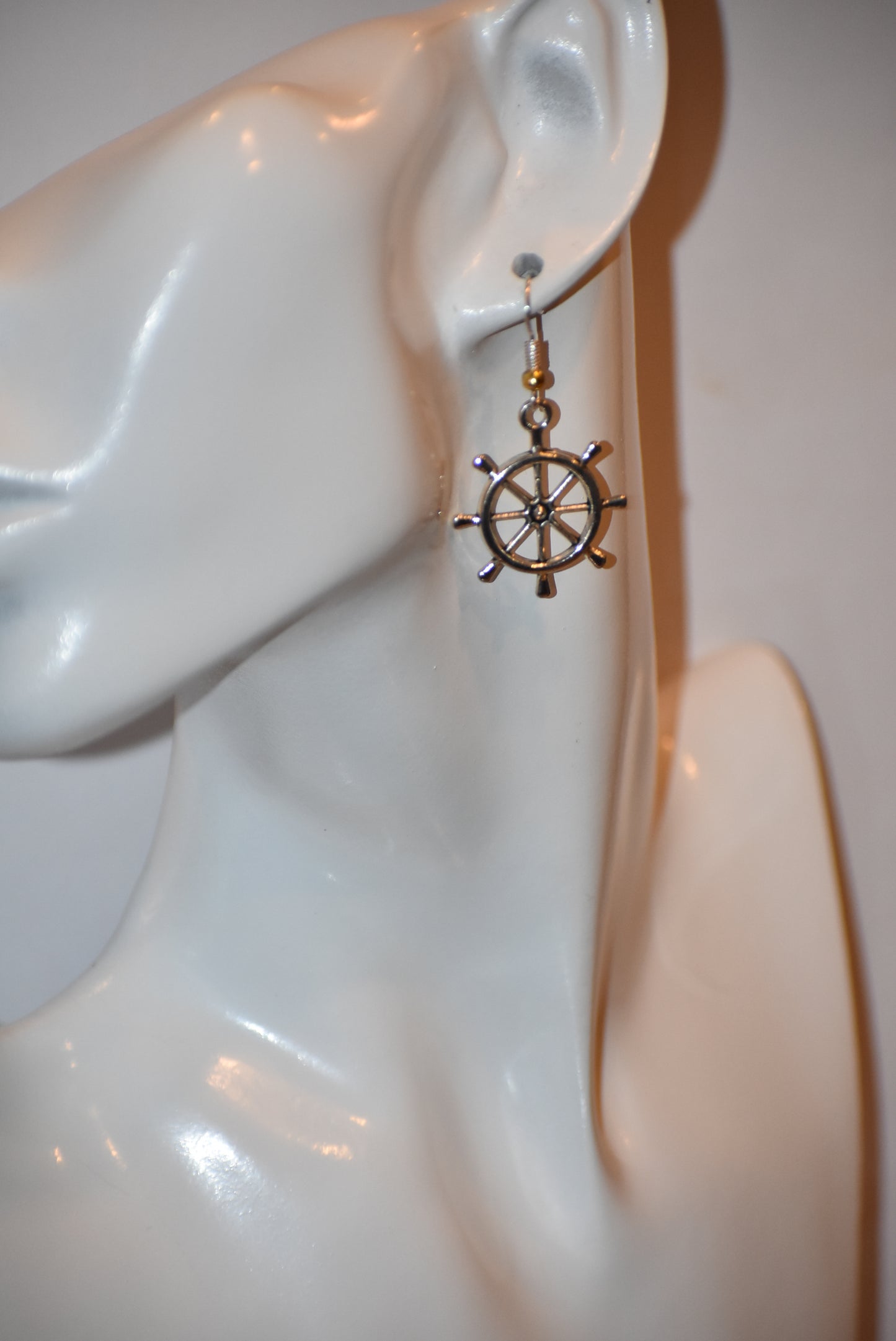 "Add some nautical charm to your look with these adorable wheel earrings ⚓ Made with hypoallergenic silver hooks and a stylish gold ball, these earrings are perfect for any outfit. Look cute and feel comfortable with the Nautical Collection!"