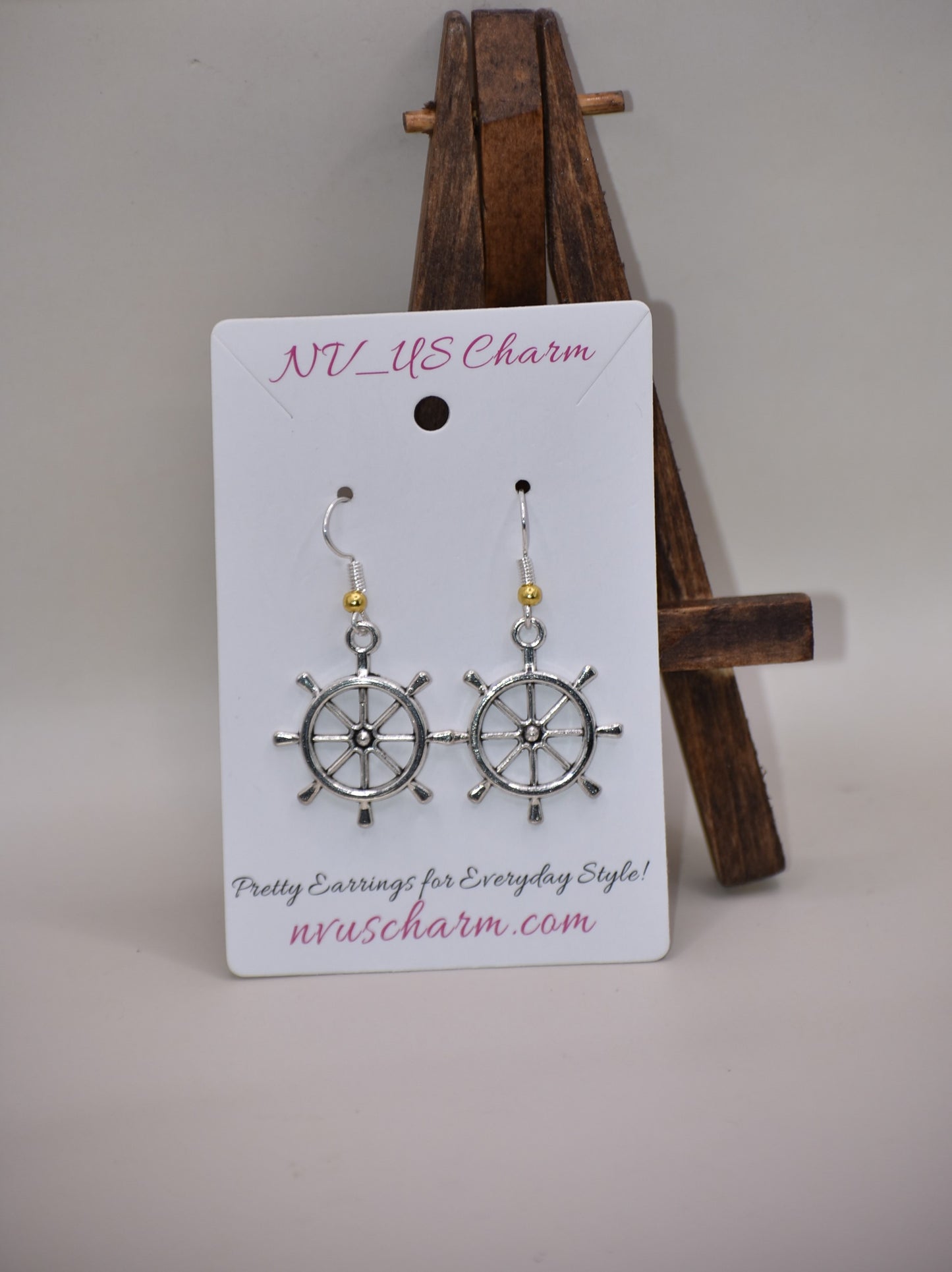 "Add some nautical charm to your look with these adorable wheel earrings ⚓ Made with hypoallergenic silver hooks and a stylish gold ball, these earrings are perfect for any outfit. Look cute and feel comfortable with the Nautical Collection!"