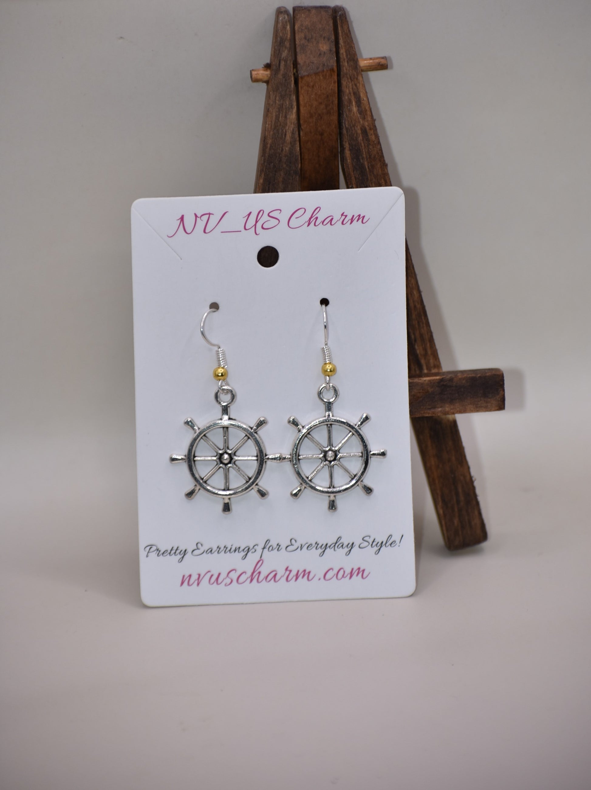 "Add some nautical charm to your look with these adorable wheel earrings ⚓ Made with hypoallergenic silver hooks and a stylish gold ball, these earrings are perfect for any outfit. Look cute and feel comfortable with the Nautical Collection!"