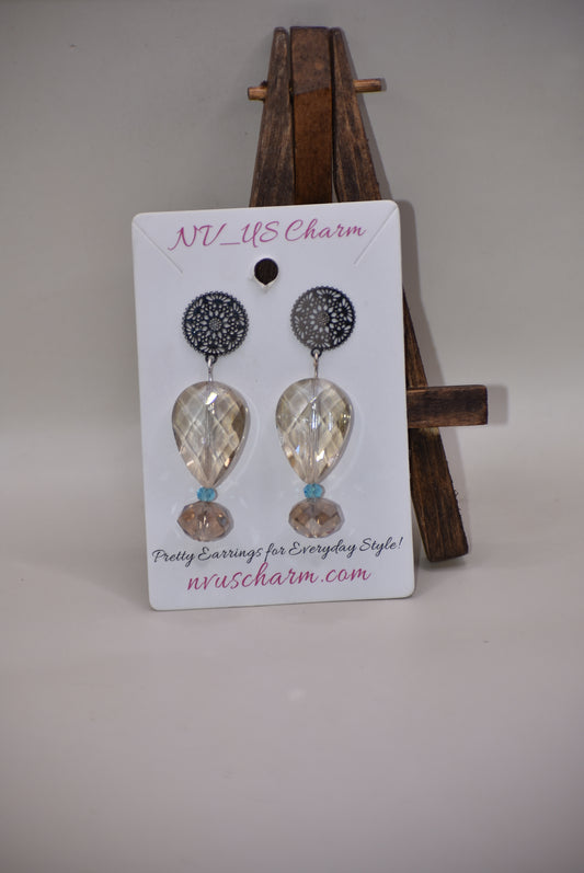 Add a touch of elegance with these Silver Filigree Flowered Post Earrings from the Yellow Collection. The pear-shaped crystal dangles playfully with a tiny aqua crystal, leading to a round crystal that sparkles just right. Make a statement with these stylish earrings!