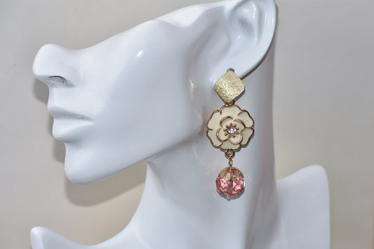 This Pink Collection 29 earring is perfect for those wanting a heavier earring with a touch of sparkle. Made with a beautiful cream colored flower and pink bead accents, the gold sparkle posts add a subtle but distinct touch.