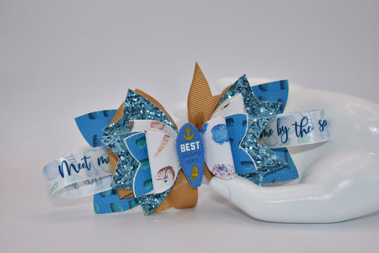 Catch some wave-ready style with Nana's Collection. This faux leather bow features a ribbon and glistening surfboard charm for a playful touch. Securely clipped in place, this one-of-a-kind accessory will make them say "Seas the day!" (Only 1 exclamation point)
