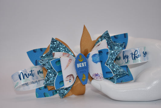 Catch some wave-ready style with Nana's Collection. This faux leather bow features a ribbon and glistening surfboard charm for a playful touch. Securely clipped in place, this one-of-a-kind accessory will make them say "Seas the day!" (Only 1 exclamation point)