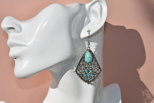 Elevate your style with the Western Collection! These silver hypoallergenic earrings feature charming Tibetan turquoise stones, hanging 38mm or 2 1/2 inches on the ear. Dress them up or down, either way, you'll love these unique statement pieces. 💎👂