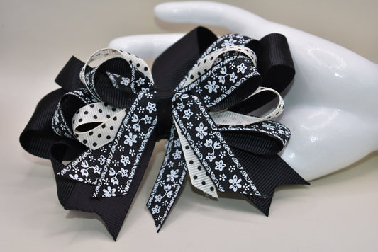 Unleash your little girl's style with Nana's Collection 76! This elegant bow is a perfect combination of black and cream, topped off with a pretty multi-mixed ribbon. The wrapped alligator clip adds ease of wear, making it ideal for any outfit. You'll love how this bow brings your little one's look to life. 🎀