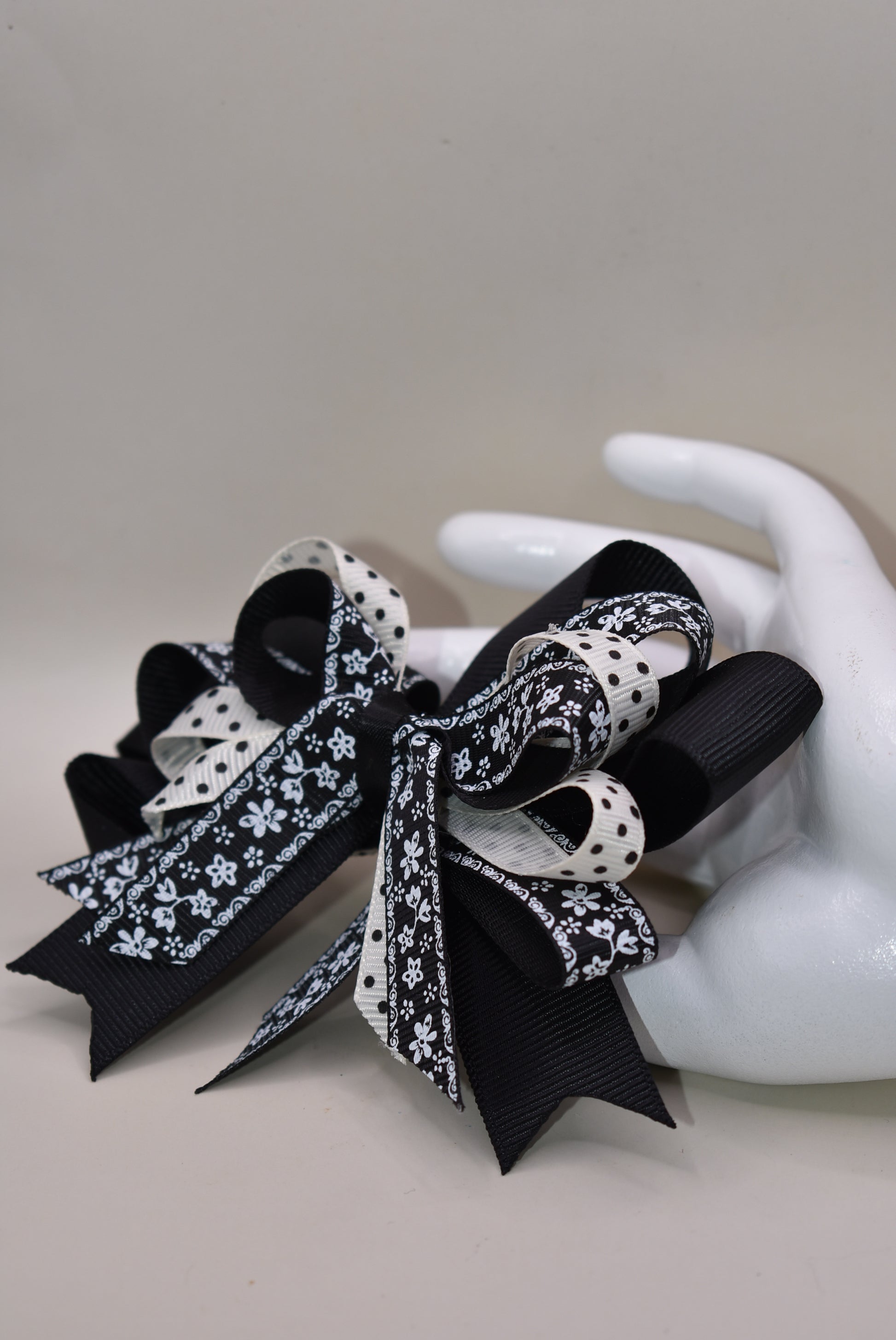 Unleash your little girl's style with Nana's Collection 76! This elegant bow is a perfect combination of black and cream, topped off with a pretty multi-mixed ribbon. The wrapped alligator clip adds ease of wear, making it ideal for any outfit. You'll love how this bow brings your little one's look to life. 🎀