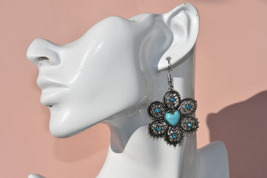 Add a pop of color to your western look with our Western Collection! 🤠 Featuring a Tibetan turquoise heart charm and sparkling crystals on hypoallergenic posts. Measures 2 1/2 inches on the ear. Yee-haw! 🌵