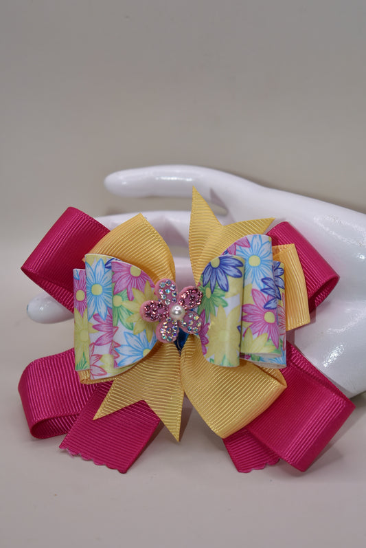 Nana's Collection 83 - Adorable faux leather flowered pattern with a colorful bow and sparkly flower to add the perfect touch to your little cutie's outfit. Includes a wrapped alligator clip for all day secure wear. #FlowerPower 🌸