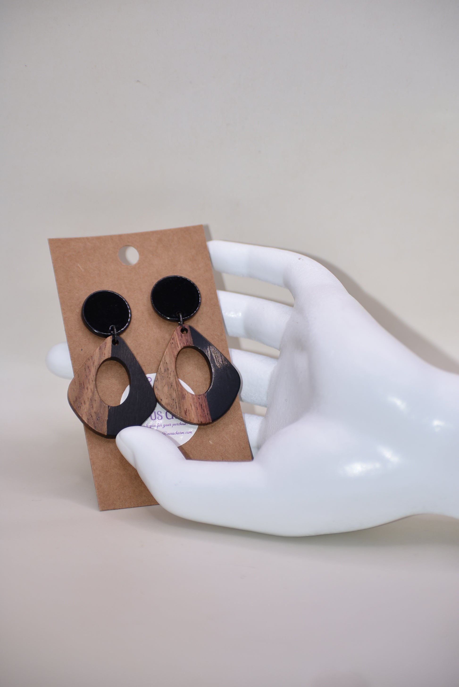 Elevate your wardrobe with our Black Collection! These stunning oval earrings, held by black round posts, will perfectly complement any outfit. Whether dressing up or down, these black resin and wood beauties are sure to make a statement. A must-have for any fashionista!